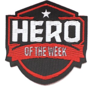 Puede incluir: Parche bordado rojo y negro con una estrella blanca y el texto "HERO OF THE WEEK".