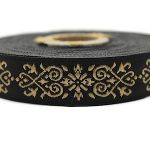 Könnte beinhalten: Schwarzes Band mit goldenem Muster. Das Muster zeigt komplizierte Wirbel und geometrische Formen.