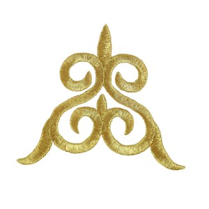 May include: Gold embroidered applique with a swirling, ornate design. The design is symmetrical and features a pointed top and a rounded bottom.