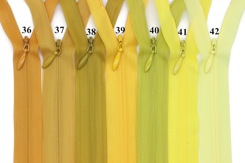 May include: Seven different colors of zipper tape, ranging from brown to yellow, with numbers 36 through 42 printed on each tape.