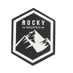 May include: Black and white embroidered patch with a hexagonal shape. The patch features a mountain range with the text "ROCKY - MOUNTAIN -" above it.