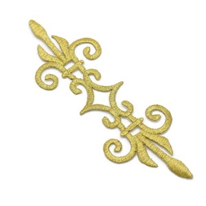 Puede incluir: Adorno decorativo bordado en oro con un diseño ornamentado y en espiral. Este adorno es perfecto para agregar un toque de elegancia a la ropa, las manualidades o la decoración del hogar.