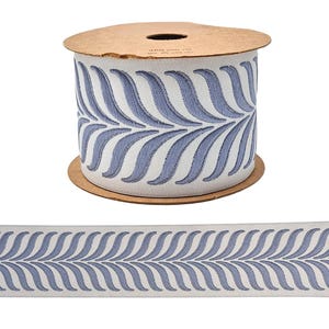 Puede incluir: Rollo de cinta decorativa con un patrón de hojas azul y blanco. La cinta se muestra en una bobina de cartón, con una muestra de la cinta desenrollada debajo. Adecuada para manualidades y decoración del hogar.