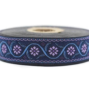 Könnte beinhalten: Eine Rolle marineblauer Besatz mit einem sich wiederholenden Muster aus lila Blüten und blauen Ranken.