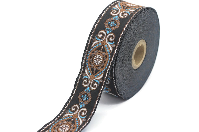 May include: Black and brown trim with a blue and white floral pattern. The trim is rolled up on a spool.