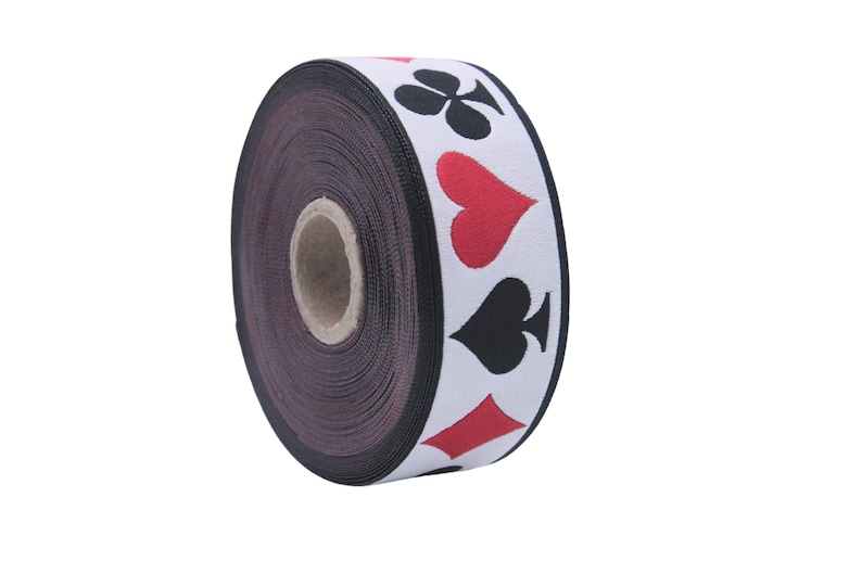 May include: A roll of white and black ribbon with red playing card symbols printed on it. The symbols are a club, a heart, a spade, and a diamond.