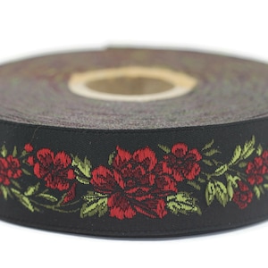 Op de afbeelding: Zwart lint met een rood en groen bloemenpatroon. Het lint is opgerold en het bloemenpatroon is zichtbaar aan de rand.