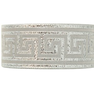 K&ouml;nnte beinhalten: Ein silber- und graues Band mit einem sich wiederholenden geometrischen Muster. Das Band ist etwa 2,5 cm breit.
