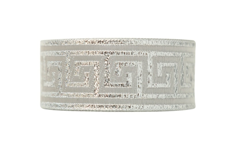 K&ouml;nnte beinhalten: Ein silber- und graues Band mit einem sich wiederholenden geometrischen Muster. Das Band ist etwa 2,5 cm breit.
