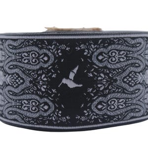 Könnte beinhalten: Schwarzes und weißes elastisches Band mit Paisley-Muster und einem kleinen Vogelmotiv in der Mitte.