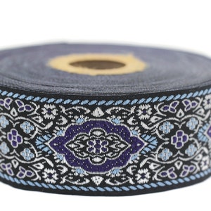 May include: A black and blue patterned trim with a white floral design. The trim is rolled up and ready to be used for sewing or crafting projects.