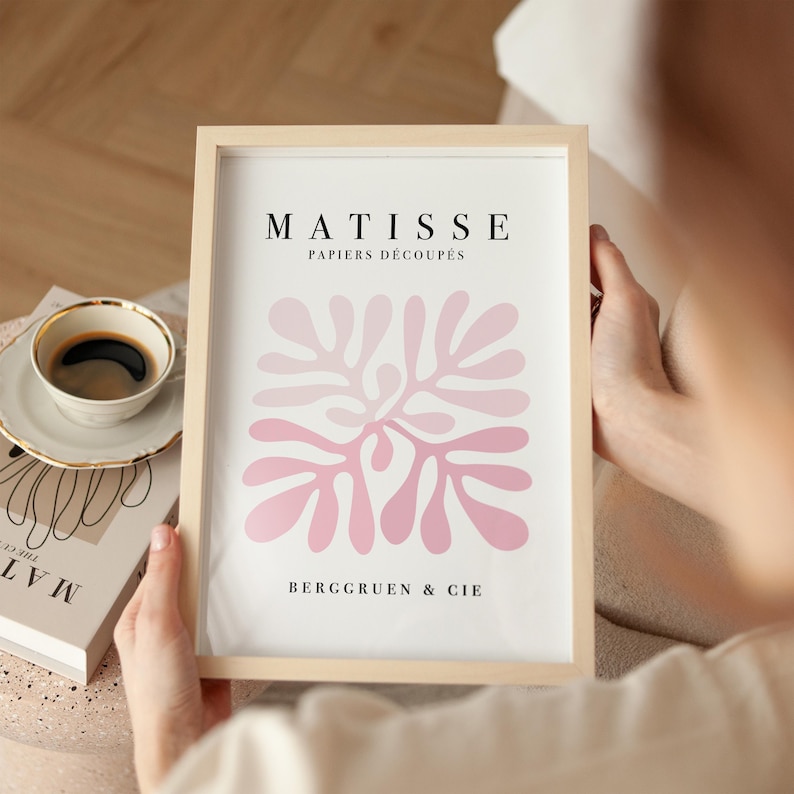 K&ouml;nnte beinhalten: Ein gerahmter Druck mit einem abstrakten Design in Rosa und dem Text "MATISSE PAPIERS DECOUPES BERGGRUEN & CIE"
