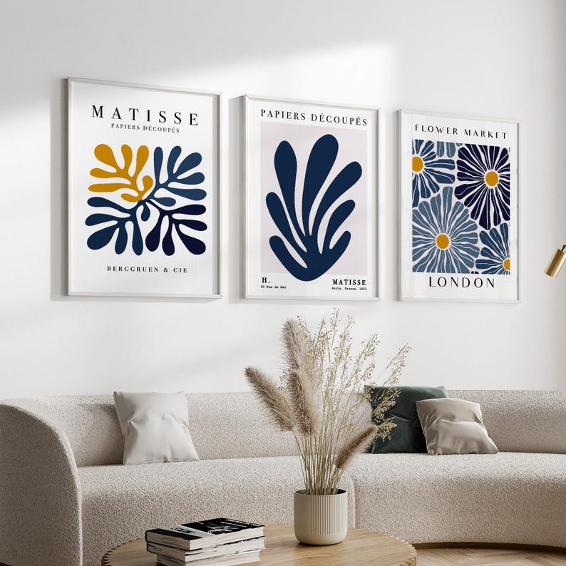 Puede incluir: Tres impresiones de arte enmarcadas con un fondo blanco y dise&ntilde;os abstractos azules y amarillos. Las impresiones se titulan "Matisse Papiers Decoupes", "Papiers Decoupes" y "Flower Market London".