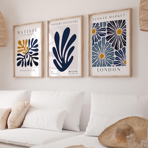Puede incluir: Tres impresiones de arte enmarcadas con un dise&ntilde;o minimalista. Las impresiones presentan formas abstractas azules y amarillas sobre un fondo blanco. La impresi&oacute;n superior dice "FLOWER MARKET LONDON". La impresi&oacute;n del medio dice "PAPIERS DECOUPES H. MATISSE". La impresi&oacute;n inferior dice "MATISSE PAPIERS DECOUPES BERGGRUEN & CIE".