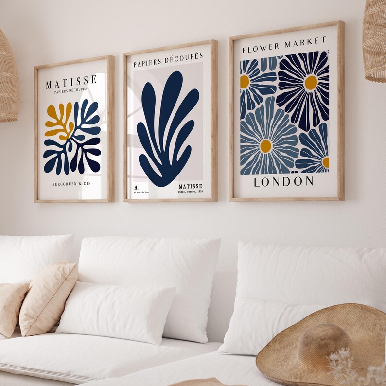 Puede incluir: Tres impresiones de arte enmarcadas con un dise&ntilde;o minimalista. Las impresiones presentan formas abstractas azules y amarillas sobre un fondo blanco. La impresi&oacute;n superior dice "FLOWER MARKET LONDON". La impresi&oacute;n del medio dice "PAPIERS DECOUPES H. MATISSE". La impresi&oacute;n inferior dice "MATISSE PAPIERS DECOUPES BERGGRUEN & CIE".