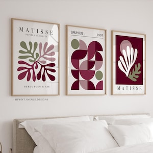 Può includere: Tre stampe artistiche incorniciate con disegni astratti. La stampa a sinistra mostra Matisse Papiers Découpés con forme organiche in oliva, malva e bordeaux. Quella centrale mostra motivi geometrici Bauhaus 1919. La stampa a destra presenta un motivo a foglie bianco e oliva su sfondo bordeaux con il testo Matisse.
