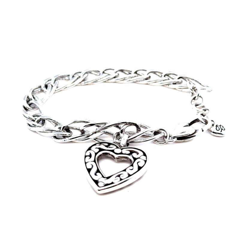 Op de afbeelding: Zilverkleurige armband met een hartvormige hanger met een open ontwerp. De hanger hangt aan een schakelarmband. De armband heeft een karabijnsluiting en een kleine decoratieve bedel.
