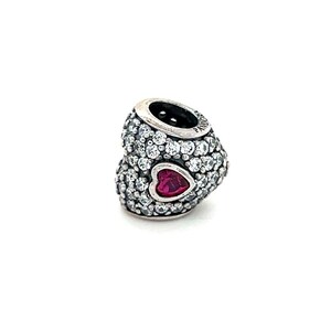 May include: Silver charm with two interlocking hearts, one with clear cubic zirconia stones and the other with a pink heart in the center.