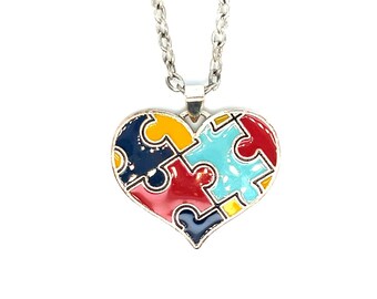 May include: A silver chain necklace with a heart-shaped pendant. The pendant is made of metal and is painted with four puzzle pieces in red, blue, yellow, and green.