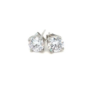 May include: A pair of silver stud earrings with clear round cubic zirconia stones.