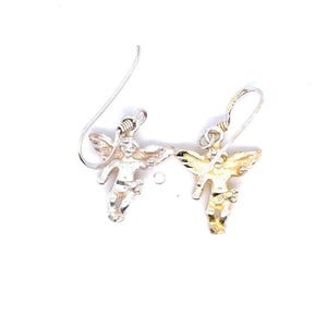 May include: A pair of silver-toned angel earrings. Each earring features a small, detailed angel figure with outstretched wings, suspended from a simple hook. The angels have a textured appearance, and the earrings are set against a white background.