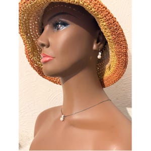 Conjunto de collar y pendientes Brighton en tono plateado con perlas blancas. imagen 11