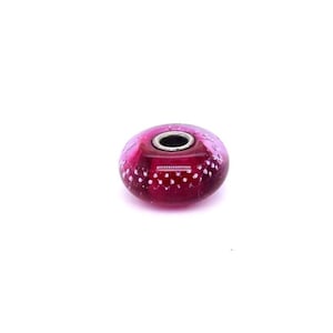 May include: A round, dark pink bead with a silver-colored metal core. The bead has a translucent appearance with small white dots scattered across its surface. The bead is isolated on a white background.