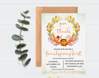 May include: An invitation for a Friendsgiving feast. The design features a watercolor wreath with orange, yellow, and red leaves and flowers. The text "give thanks" is at the top. A brown envelope and eucalyptus sprig are on a white wood background.