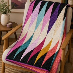 May include: A quilt featuring a repeating pattern of elongated diamond shapes in various colors including black, teal, magenta, purple, and cream. The fabric pieces are joined with visible stitching and finished with a solid magenta fabric border.