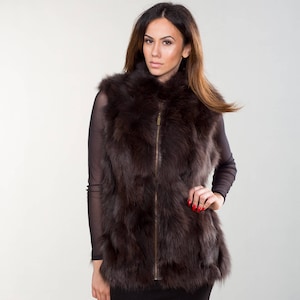 May include: A brown fur vest with a zipper closure. The vest is sleeveless and has a high collar.