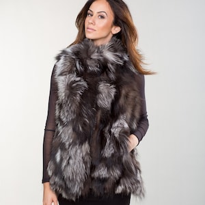 May include: A silver fox fur vest with a zipper closure. The vest is made of soft, luxurious fur and has a classic, elegant design.