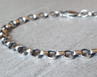 May include: A silver chain bracelet with a clasp closure. The chain is made of small, oval-shaped links.
