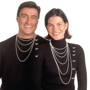 May include: Two models wearing black mock neck shirts, showcasing different lengths of silver chain necklaces. The necklaces are labeled with measurements in inches, ranging from 16 to 36 inches.