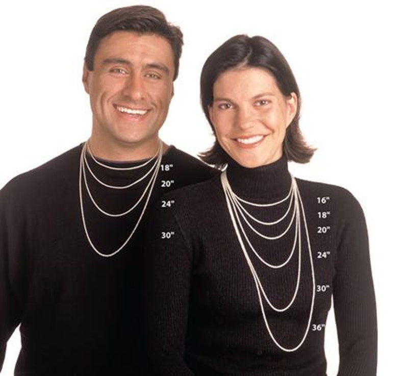May include: Two models wearing black mock neck shirts, showcasing different lengths of silver chain necklaces. The necklaces are labeled with measurements in inches, ranging from 16 to 36 inches.