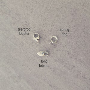 May include: Three different types of jewelry clasps: a teardrop lobster clasp, a long lobster clasp, and a spring ring clasp.