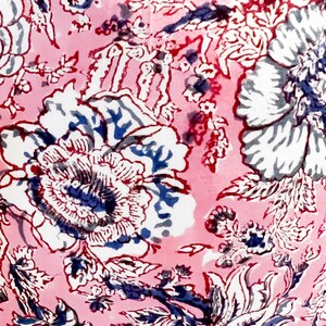 May include: Pink fabric with a white and blue floral pattern. The fabric has a vintage feel and is perfect for crafting projects.
