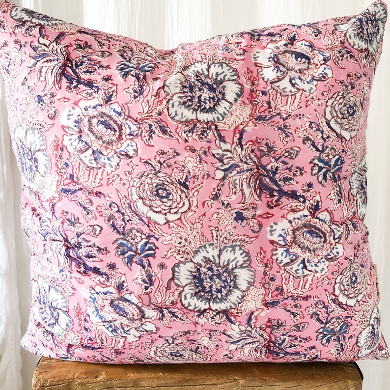 May include: Pink floral pillow cover with a white and blue floral pattern. The pillow cover is made of a soft, cotton fabric and is perfect for adding a touch of color and style to any room.