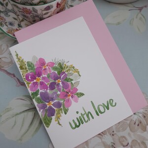 Tarjeta de felicitación en blanco con flores rosas y moradas