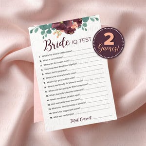 May include: A bridal shower game card with a floral design at the top, featuring the text "Bride IQ TEST." A circular sticker reads "2 Games!" The card includes questions to test the bride's knowledge.