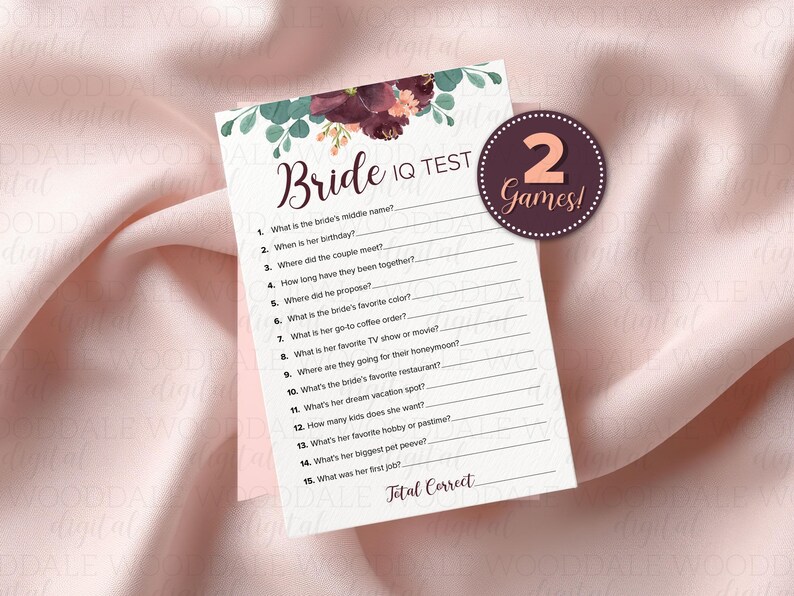 May include: A bridal shower game card with a floral design at the top, featuring the text "Bride IQ TEST." A circular sticker reads "2 Games!" The card includes questions to test the bride's knowledge.