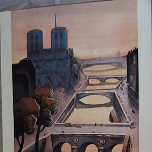May include: A vintage postcard featuring a colorful illustration of the Notre Dame Cathedral in Paris, France. The postcard depicts the cathedral with two bridges in the foreground and the text "PARIS" in bold black letters.