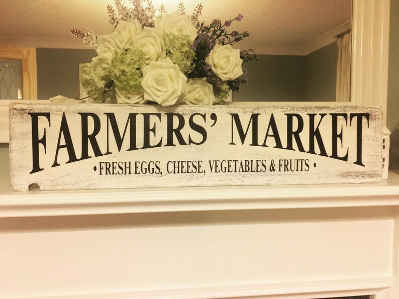 Peut inclure: Une enseigne en bois blanc avec des lettres noires qui disent "Farmers' Market" et "Fresh Eggs, Cheese, Vegetables & Fruits".