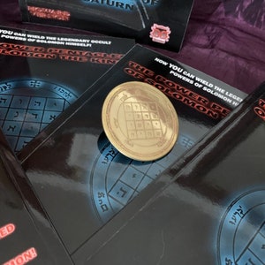 May include: Three black books with gold lettering and a gold metal pentagram charm. The books have the title "The Power Pentacle of Solomon" and the text "Now you can wield the legendary occult powers of Solomon himself!"