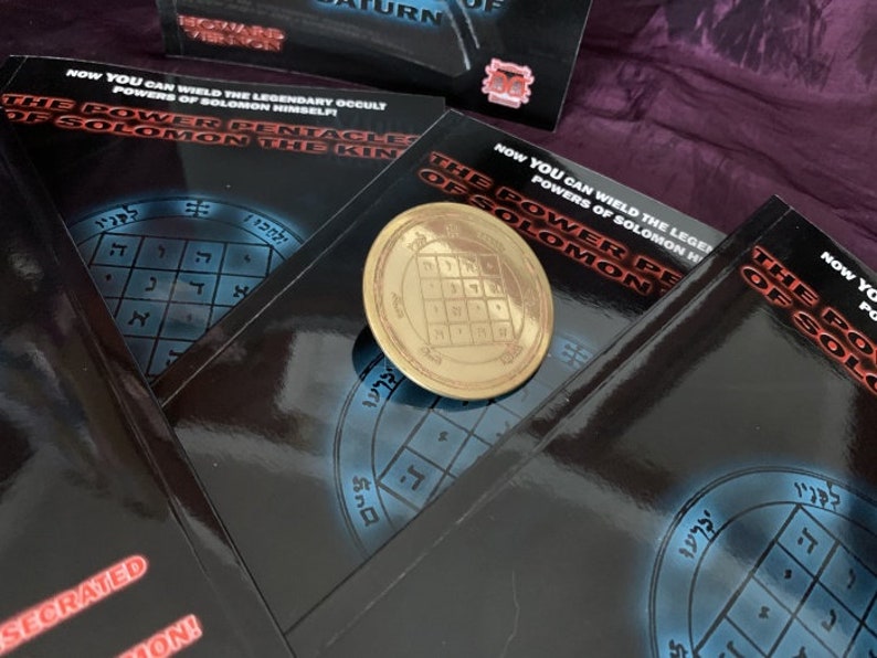 May include: Three black books with gold lettering and a gold metal pentagram charm. The books have the title "The Power Pentacle of Solomon" and the text "Now you can wield the legendary occult powers of Solomon himself!"