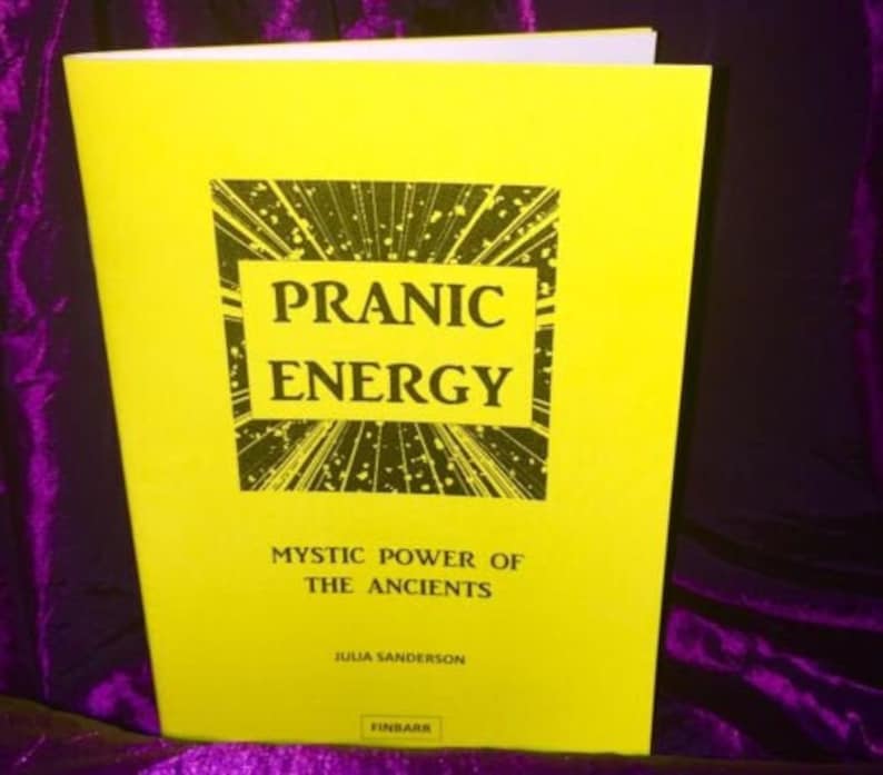 May include: A yellow book with the title "Pranic Energy: Mystic Power of the Ancients" by Julia Sanderson. The cover features a black and white illustration of radiating lines.