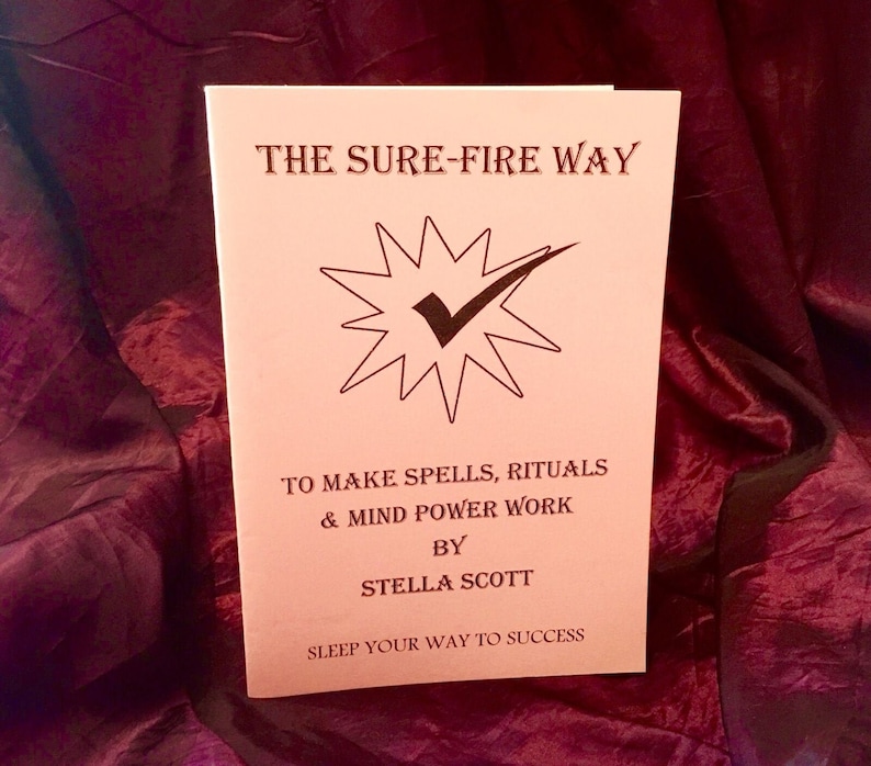 May include: A pink book titled "The Sure-Fire Way to Make Spells, Rituals & Mind Power Work" by Stella Scott. The book cover features a black checkmark inside a starburst. The text "Sleep Your Way to Success" is printed below the author's name.