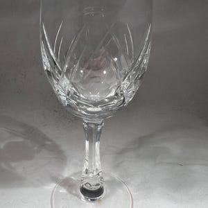 Peut inclure: Un verre à vin en verre transparent avec un motif en cristal taillé. Le verre a un bol rond et une longue tige avec une base circulaire.