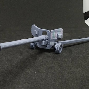 May include: A gray 3D printed model of a cannon with wheels and a long barrel.