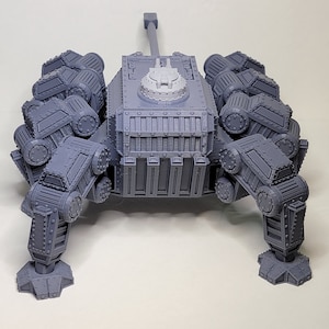 May include: A gray, 3D printed, multi-legged, tank-like model with a large cannon on top. The model has a detailed, textured surface and appears to be a miniature.