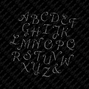 May include: A black background with the alphabet in white, outlined with small, white, round rhinestones. The letters are in a cursive font.